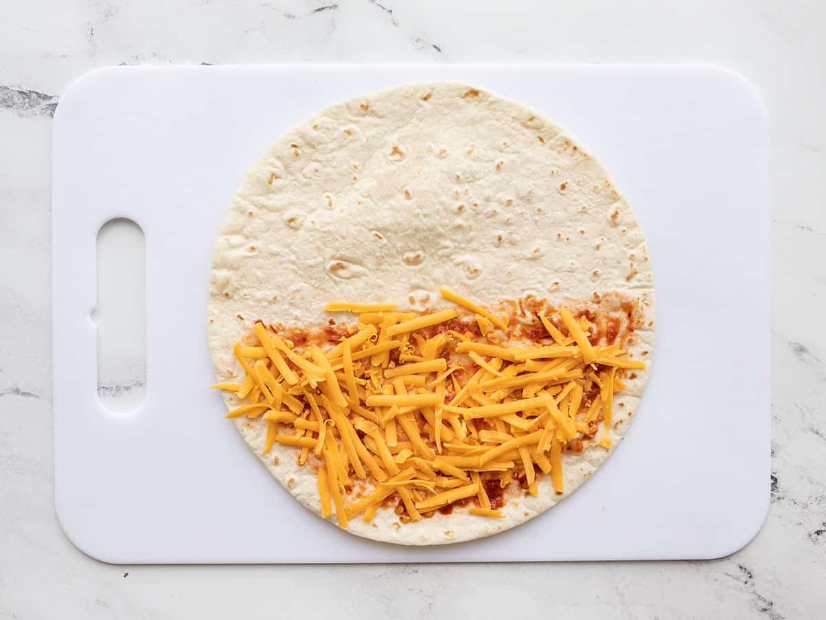 shredded cheese on tortilla