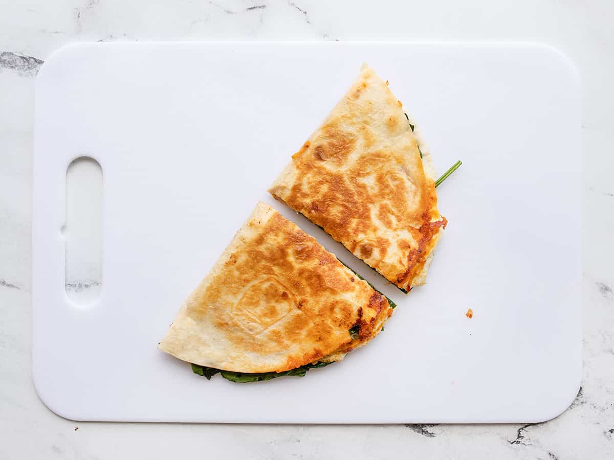 quesadilla cut in half on the cutting board