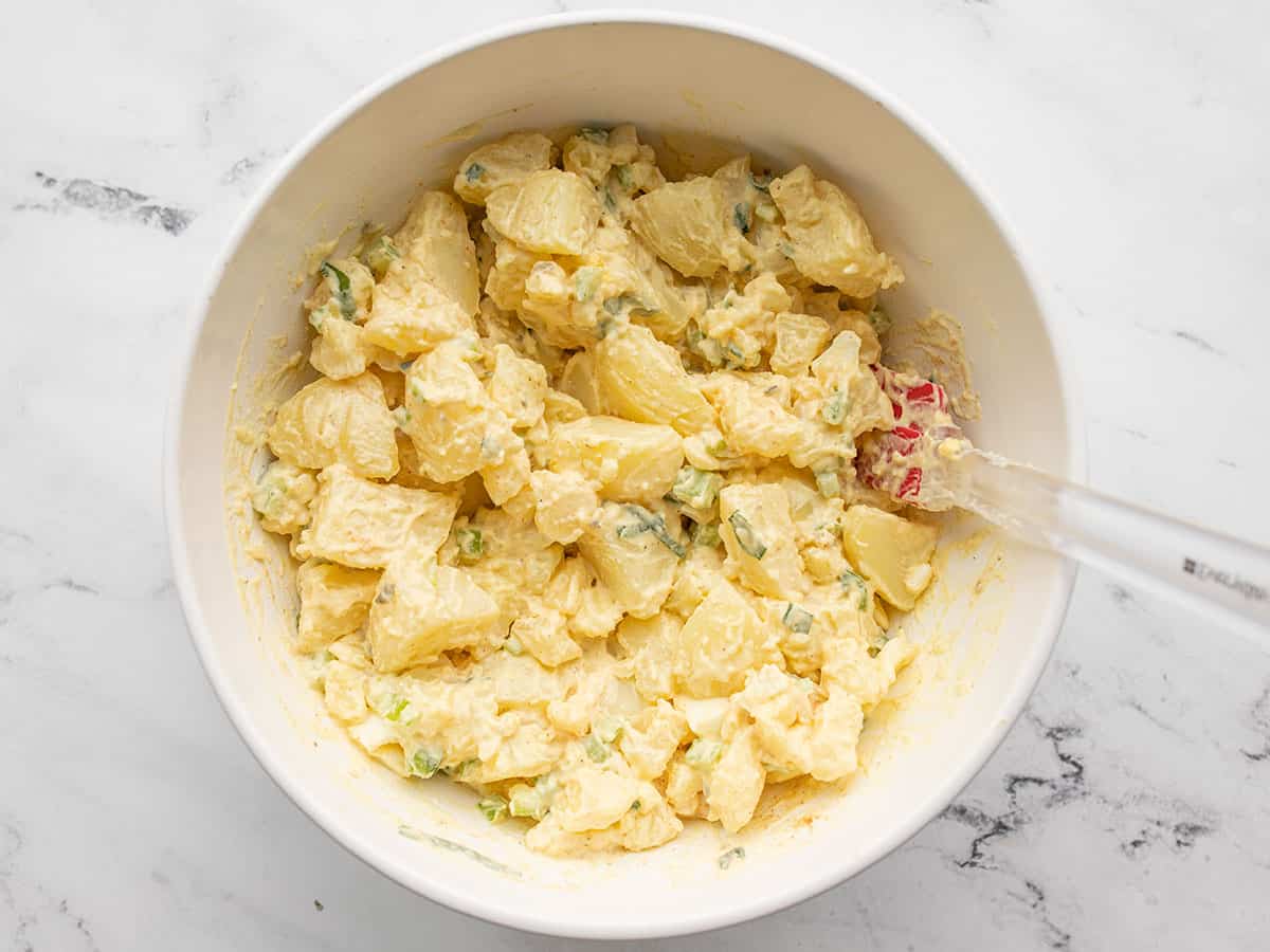 Finished potato salad in a bowl with a spatula