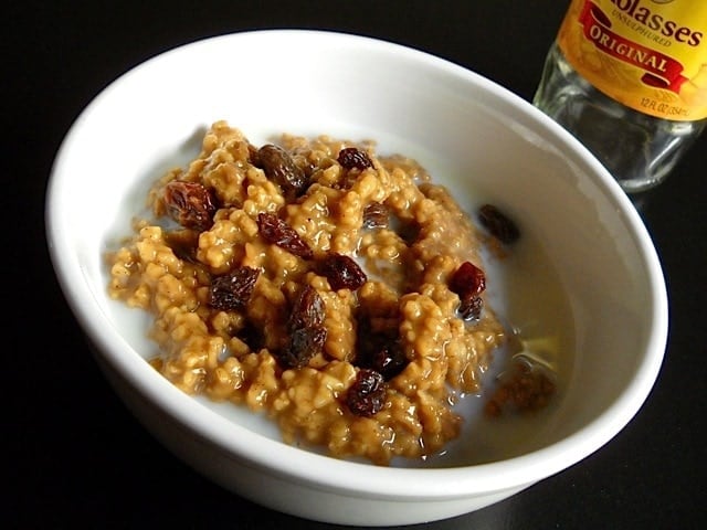 Bowl of gingerbread oatmeal topped with dried cranberries.