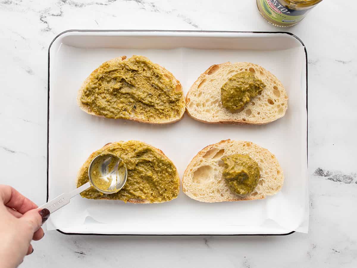 pesto being spread onto the bread