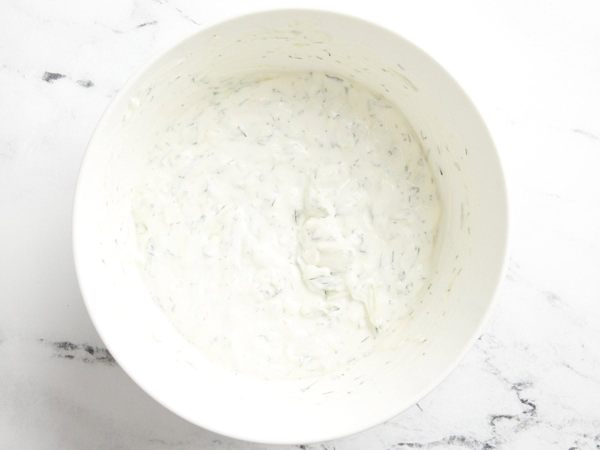 Tzatziki sauce in a white serving bowl.