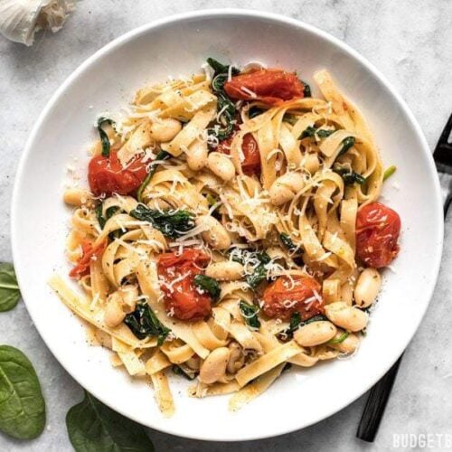 This Tuscan White Bean Pasta is a fast and flavorful dish that is perfect for weeknight dinners. The caramelized garlic, basil, and Parmesan pack a huge flavor punch! BudgetBytes.com