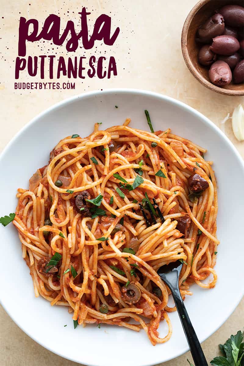 A bowl of pasta puttanesca with a fork in the middle and title text at the top