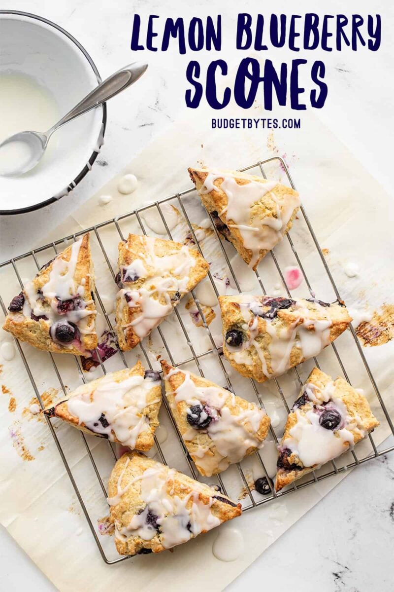 Lemon blueberry scones on a wire cooling rack with lemon glaze