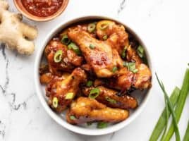 Overhead view of a bowl full of sticky ginger chicken wings