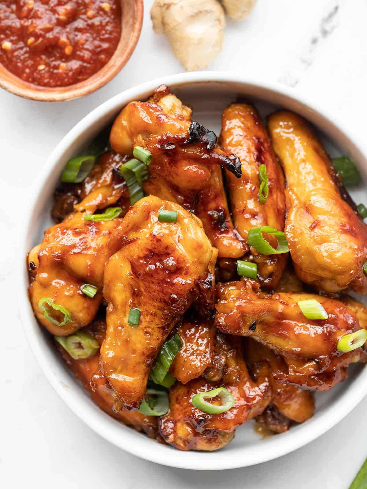 Overhead view of a bowl full of sticky ginger chicken wings