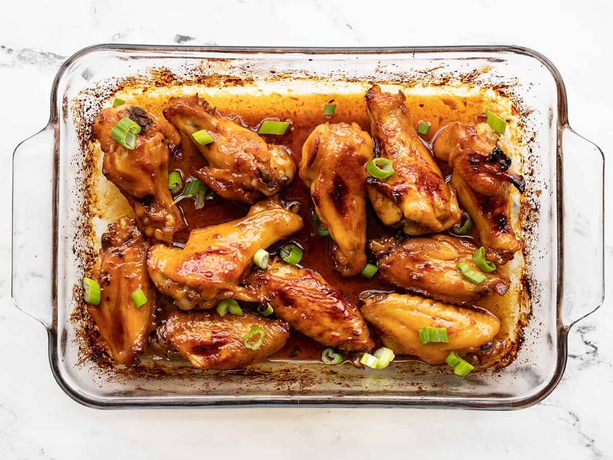 Finished sticky ginger chicken wings topped with sliced green onions