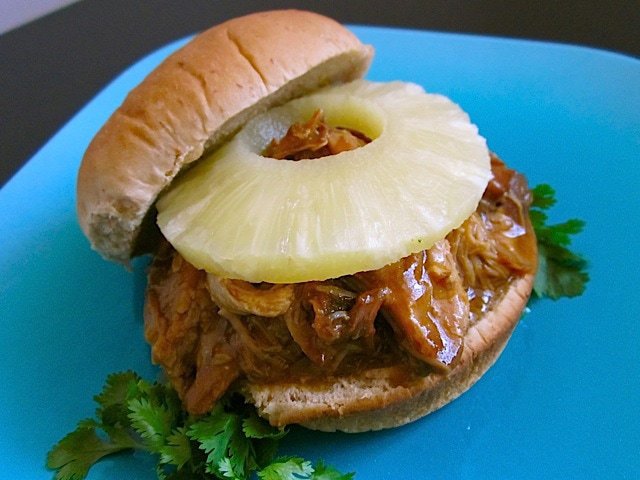 Teriyaki pork sandwich with colorful toppings.