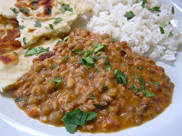 Close-up of dal served with basmati rice and naan bread.