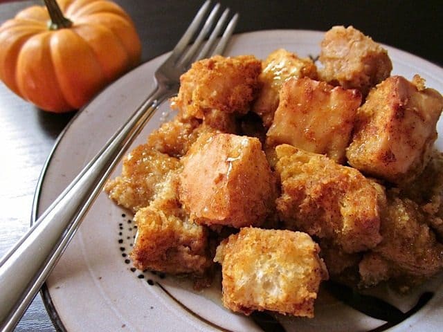 Close-up of pumpkin bread pudding with caramel alongside a pumpkin.