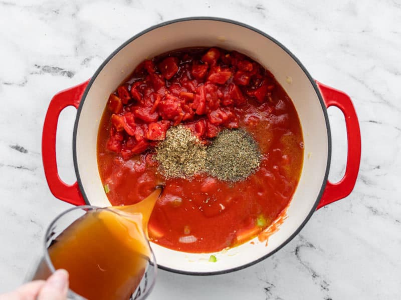 Add tomatoes, herbs, and vegetable broth to soup pot