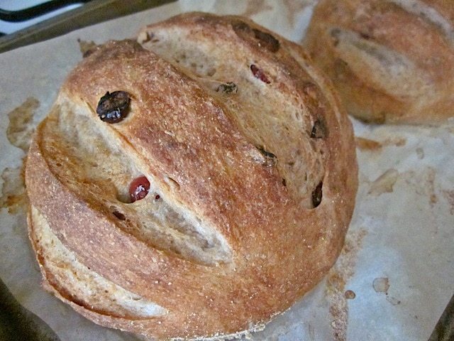 Baked cranberry walnut bread presented on baking sheet.