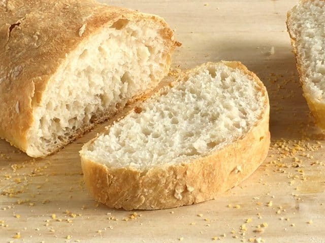 Sliced no-knead ciabatta loaf on a cutting board.