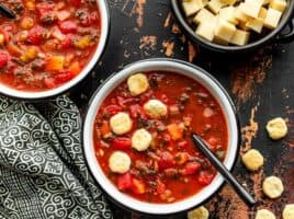 Two bowls of Swamp Soup with a bowl of Swiss cheese on the side, plus a few oyster crackers