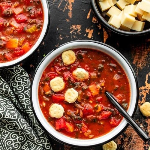 Two bowls of Swamp Soup with a bowl of Swiss cheese on the side, plus a few oyster crackers