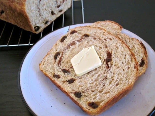 Slice of cinnamon raisin bread spread with butter.