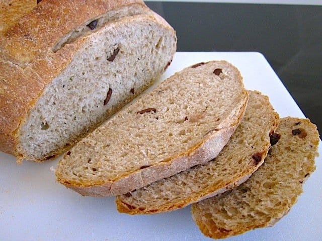 Close-up of sliced olive bread on a board.