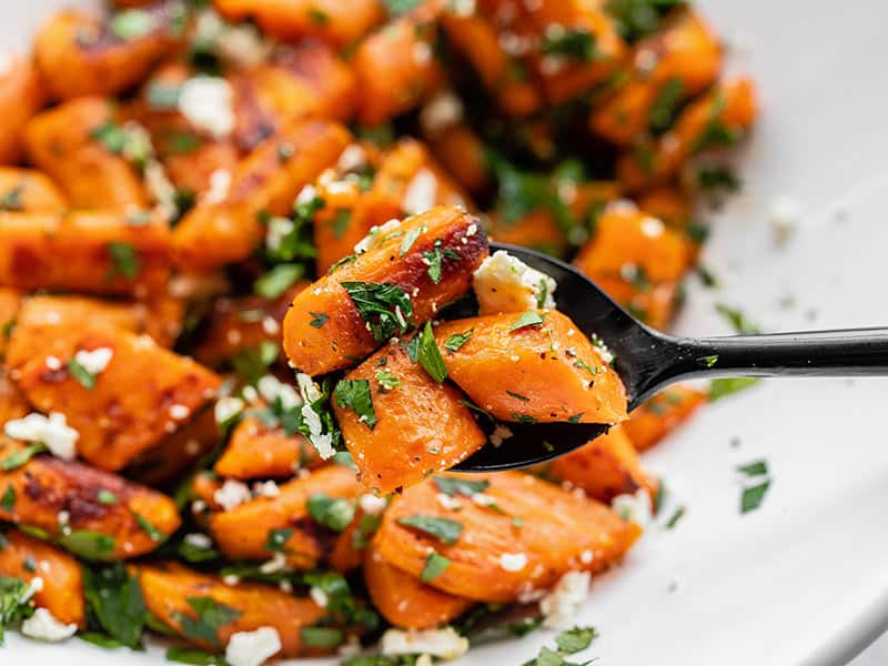 Close up of Roasted Carrot and Feta Salad, a spoon holding a few pieces close to the camera