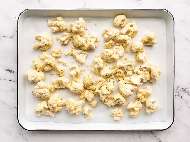 Cauliflower on a lined baking sheet ready to roast