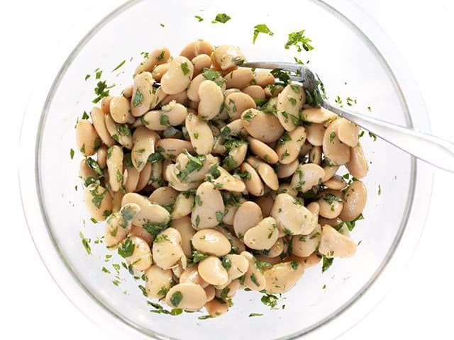 Top view Mixed Marinated White Beans in bowl with spoon 