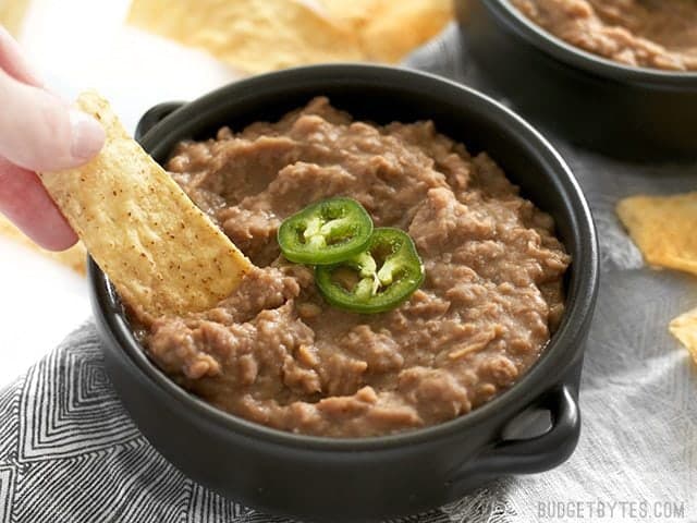 Chips being dipped into slow cooker (not) Refried Beans