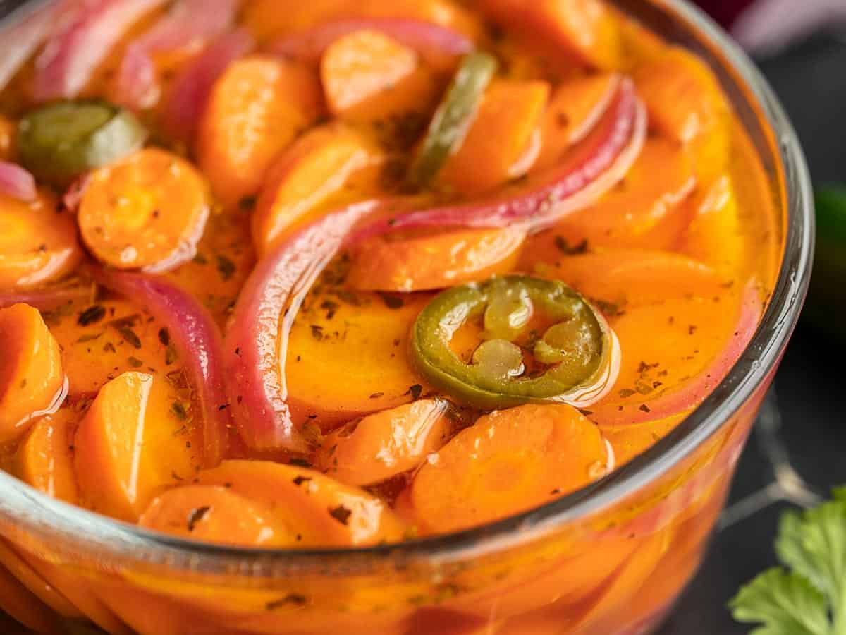 Close up side view of spicy pickled carrots.