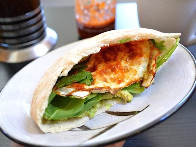 Avocado and egg pita sandwich on a plate.