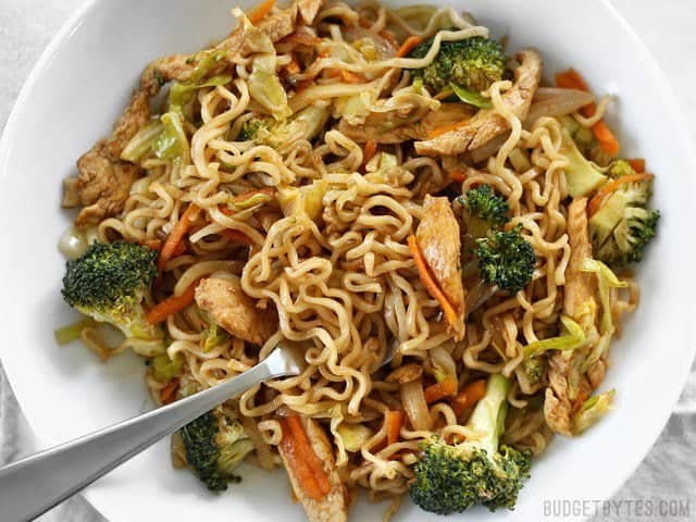 A large bowl of Chicken Yakisoba with a fork stuck in the side