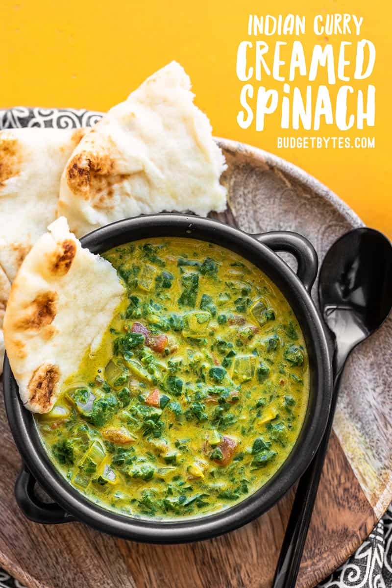 A bowl full of Indian Style Creamed Spinach with title text at the top