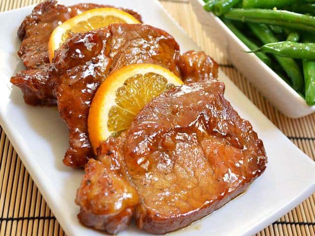 Orange molasses pork chops on a serving plate.