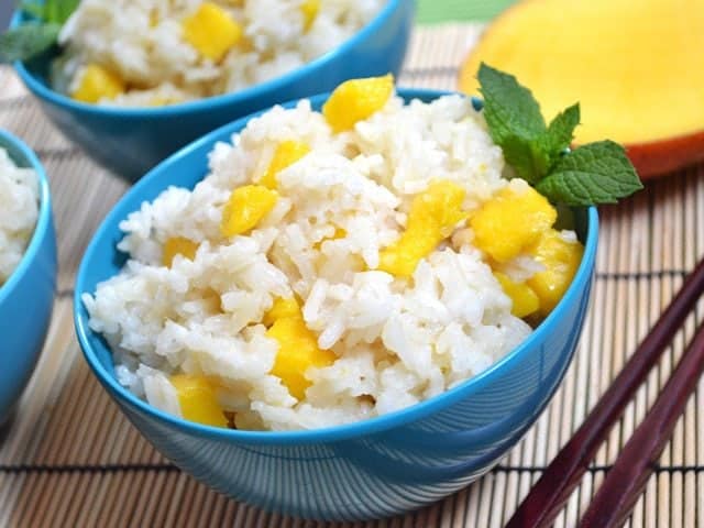 Mango coconut rice in a bowl with chopsticks.