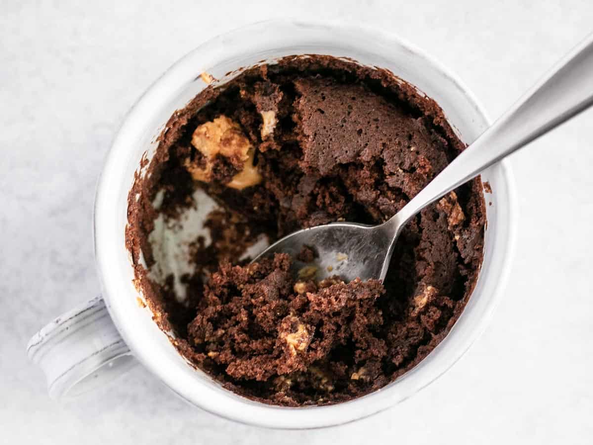 half eaten mug cake with a spoon resting in the middle.