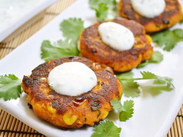 Sweet potato corn cakes drizzled with sauce.