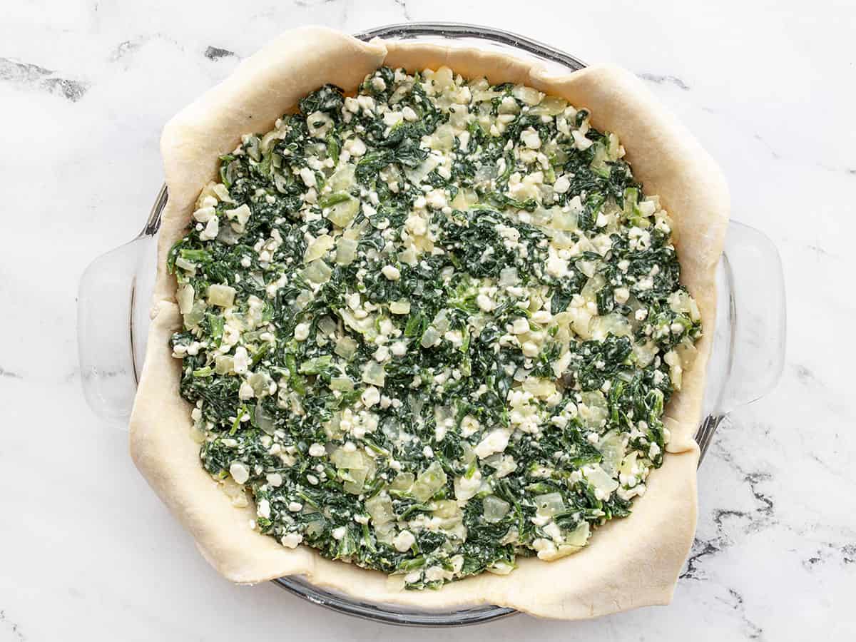 Spinach pie filling added to the pie plate