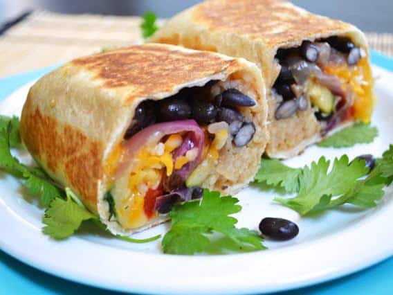 Roasted black bean vegetable burritos on a plate.