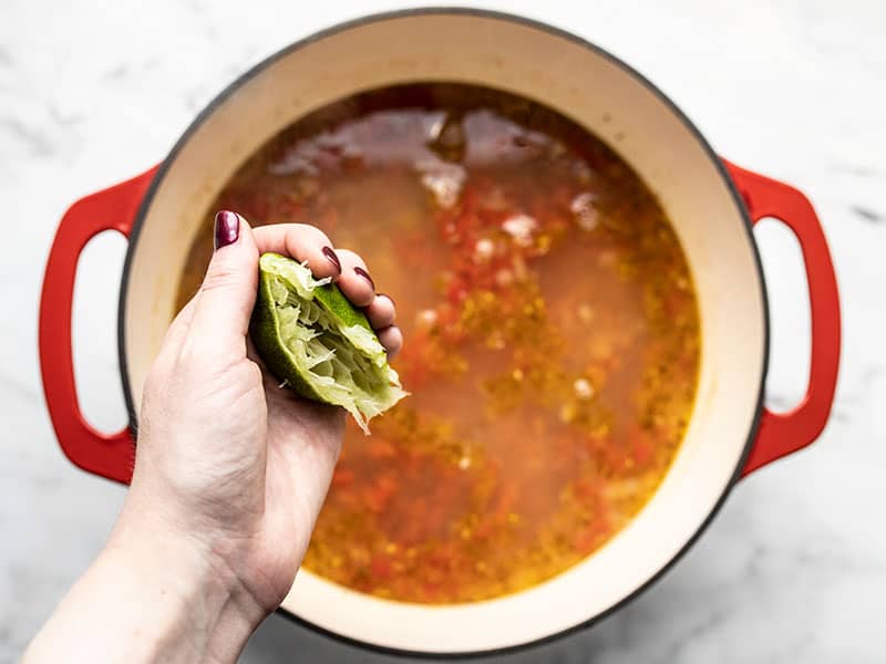 Squeezing half lime into the soup.