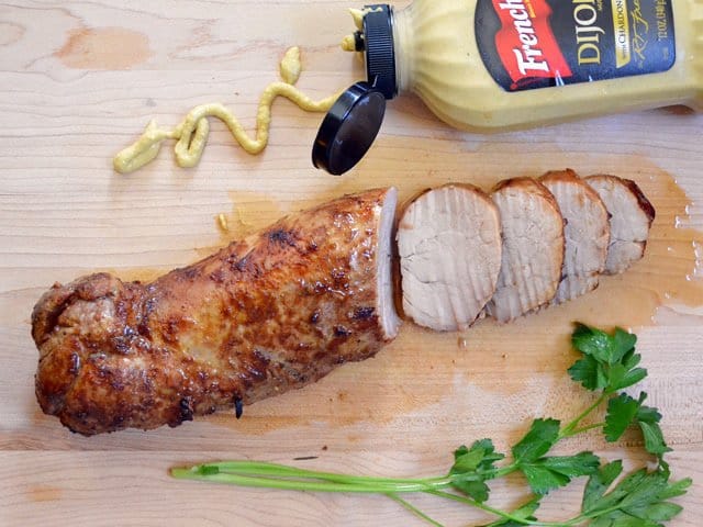 Soy dijon pork loin on a wooden cutting board.