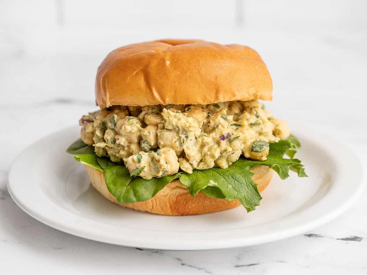 Pesto chickpea salad on a bun with greens