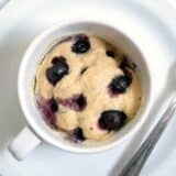 A white mug filled with a muffin mix.