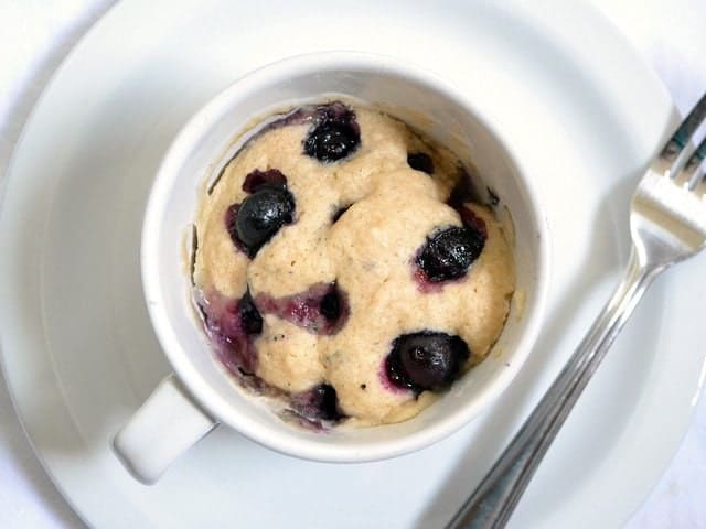 A white mug filled with a muffin mix.