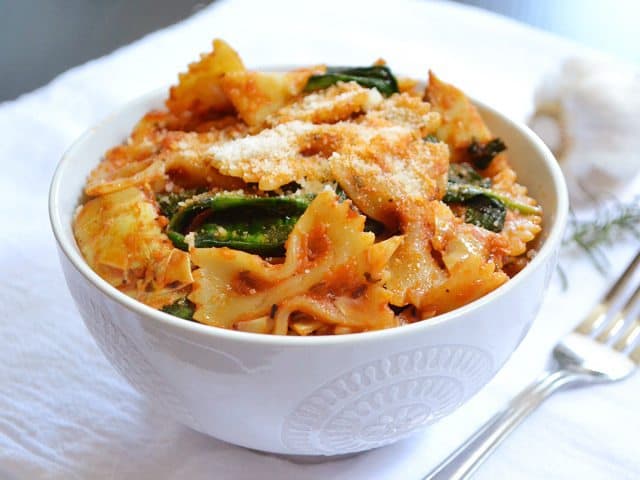 Zesty tomato and artichoke pasta served in a bowl.