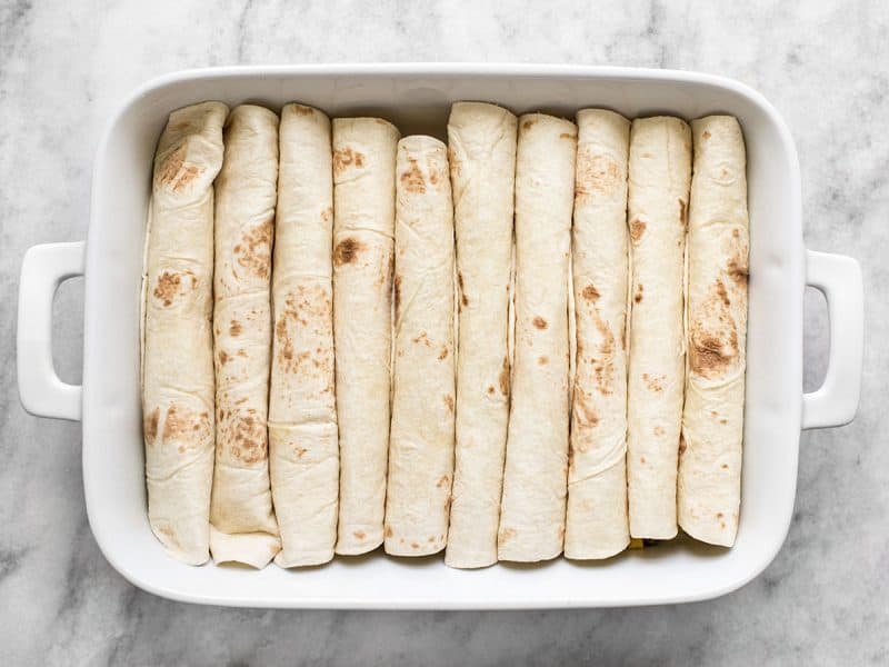 Filled and rolled enchiladas in casserole dish