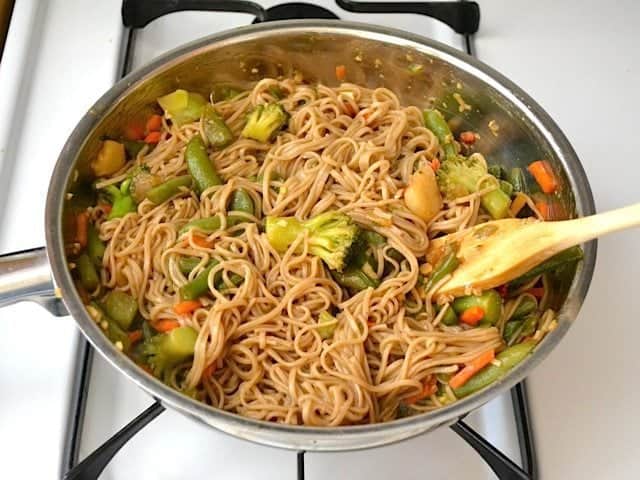 Cooked Noodles added to skillet with stir fry veggies and sauce 