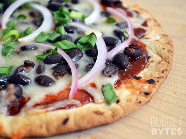 A close-up of BBQ black bean pizza with toppings.