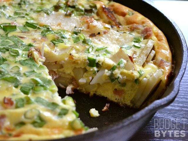 A skillet of ham and potato frittata with herbs.