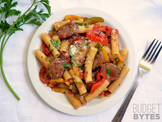 Sausage and pepper pasta served in a plate with a fork.