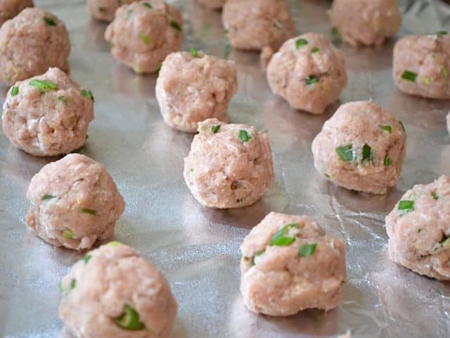 Meatball mix formed into meatballs and placed on baking sheet 