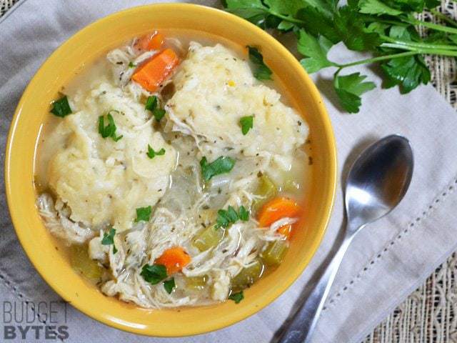 A bowl of chicken and dumplings served with gravy.