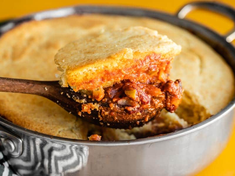 Close up of chili cornbread skillet being scooped out of the skillet